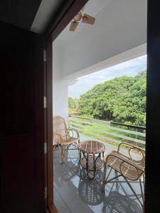 a balcony with a table and chairs and a view at MATHER RAJAGIRI FURNISHED APARTMENTS in Alwaye