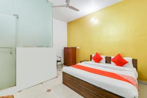 a bedroom with a bed with red pillows at Super OYO Hotel Olive in Rohtak