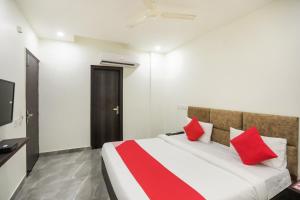 a bedroom with a large bed with red pillows at Hotel Krishna in Faridabad