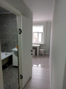 - une porte ouverte menant à une salle de bains pourvue d'un lavabo et de toilettes dans l'établissement Orda, à Kyzylorda