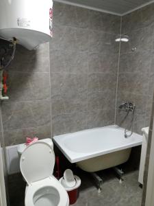 a bathroom with a toilet and a sink and a bath tub at Orda in Qyzylorda