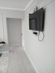 einen Flachbild-TV, der an einer weißen Wand hängt in der Unterkunft Orda in Qysylorda
