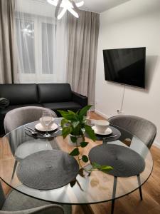 a living room with a glass table and chairs at Apartament Karoliny 2 self check-in, parking in Rzeszów