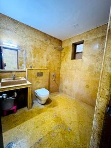 a dirty bathroom with a toilet and a sink at Abu Safari Jaisalmer in Jaisalmer