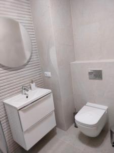 biała łazienka z umywalką i toaletą w obiekcie Apartament Karoliny 2 self check-in, parking w mieście Rzeszów
