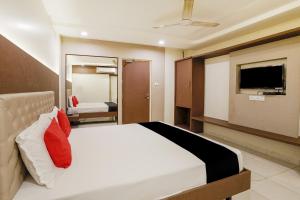 a hotel room with a bed and a tv at Hotel Sapna Near Anand Nagar (Dahisar) Metro Station in Mire
