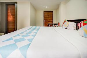 a large white bed in a room with at Sayhallo Prime Residency in Bhubaneshwar
