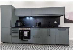 a kitchen with gray cabinets and a stove at Gorgeous Home VERY Close to the Fast Tube! in London