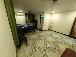 een kamer met een blauw bed en een tegelvloer bij Ashirvad cottage in Alībāg