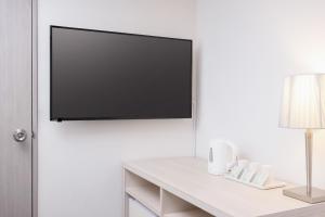 a flat screen tv hanging on a white wall at Auberge Amanohashidate in Miyazu