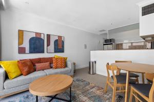 een woonkamer met een bank en een tafel bij Discover Bond Street in Sydney