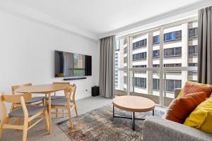 a living room with a table and a couch at Discover Bond Street in Sydney