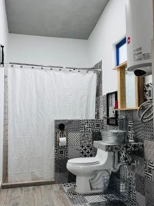 - une salle de bains en noir et blanc pourvue de toilettes et d'un lavabo dans l'établissement Casa De Campo Mirador H&L, à San Antonio de las Alzanas