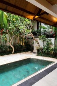 a swimming pool in front of a house at Villa Baru 3 Bedroom in Tabanan