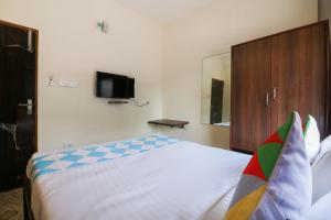 um quarto com uma cama e uma televisão na parede em Adri Hotels Near Dum Dum Metro Station em Dum Dum