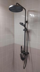 een douche met een douchekop in de badkamer bij Haruka 紫 in Naha
