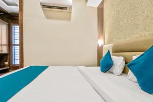 una camera da letto con un grande letto con cuscini blu di Super OYO SilverKey Park Circus Near Birla Mandir a Ballygunge