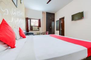 a bedroom with a large white bed with red pillows at Flagship Ki & Ka Villa in Patna
