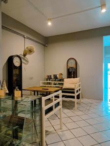 8 SLEEPER STREET Guesthouse في مينْغكرابي: غرفة معيشة مع طاولة وساعة