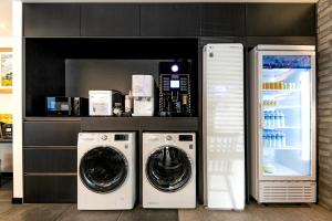 a laundry room with a washer and dryer and a refrigerator at Hotel Yaja Masan Odong Branch in Masan