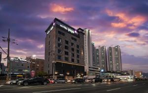 a tall building with cars parked on a city street at Hotel Yaja Masan Odong Branch in Masan