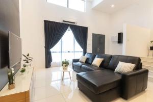 a black leather couch in a living room with a window at Ayu Homestay in Klang