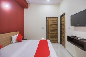 a bedroom with a bed and a flat screen tv at OYO Sewa Residency in Faridabad