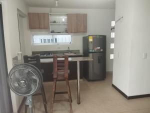 a kitchen with a refrigerator and a table and a fan at SANTAFE APARTASOLES in Santa Fe de Antioquia