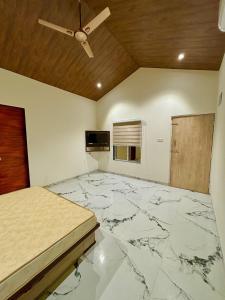 1 dormitorio con suelo de mármol y techo en Tara's Hill Resort en Lonavala