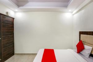 a bedroom with a bed with red pillows on it at OYO Flagship New Daffodil Inn in Ballabgarh