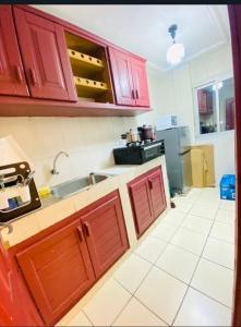 Guesthouse & énergie في دوالا: مطبخ مع دواليب حمراء ومغسلة