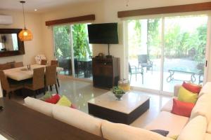 uma sala de estar com um sofá e uma mesa em Villa Gardens, Beach Front (Santuarios de la bahia em Nuevo Vallarta 