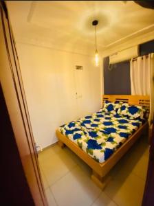 Guesthouse & énergie في دوالا: غرفة نوم بسرير لحاف ازرق وبيض