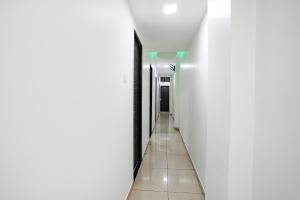 FabHotel Park Residency في مومباي: ممر به جدران بيضاء وأرضية من البلاط الأبيض