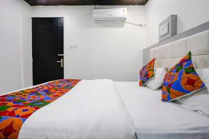 FabHotel Park Residency في مومباي: غرفة نوم مع سرير كبير مع بطانية ملونة