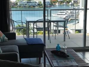 ein Wohnzimmer mit einem Tisch und Hafenblick in der Unterkunft Spectacular Marina Views Apartment in Larrakeyah