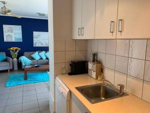 eine Küche mit einem Waschbecken und ein Wohnzimmer in der Unterkunft Spectacular Marina Views Apartment in Larrakeyah