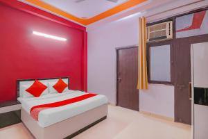 a red bedroom with a bed and a red wall at Primrose Hotel's Near Noida Sector Metro Station in Noida