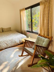um quarto com uma cama, uma cadeira e uma mesa em Elephant's House - Đường Lâm Homestay em Hanói