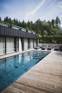 uma casa com uma piscina ao lado de um deque de madeira em nancy's Holiday Homes Dolomites em Rasùn di Sotto