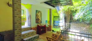 uma sala de estar com paredes verdes e uma varanda em GreenView Backpacker INN em Ubud