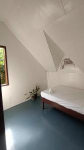 a white room with a bed and a window at KALAYAAN INN in Port Barton