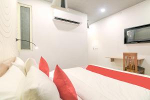 a bedroom with a bed with red pillows at Collection O Jps Grand Hotel Near Dwarka Metro Station in New Delhi