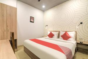 新德里的住宿－Collection O Jps Grand Hotel Near Dwarka Metro Station，一间卧室配有一张带红色枕头的大床