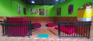 um quarto com paredes verdes e camas vermelhas em GreenView Backpacker INN em Ubud