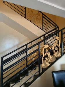 a staircase with wrought iron railings and a chandelier at Kigali Peace vill in Kigali