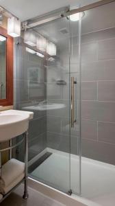 a glass shower in a bathroom with a sink at Marriott Saddle Brook in Saddle Brook
