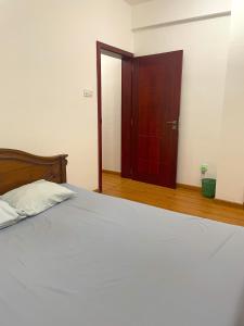1 dormitorio con 1 cama y puerta de madera en Rush Resident Mount Lavinia en Mount Lavinia