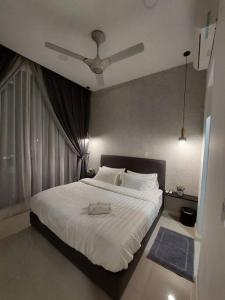 um quarto com uma grande cama branca e uma ventoinha de tecto em Walk to Legoland * D'Pristine * 2BR Pool View #7 em Nusajaya
