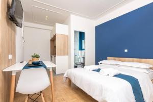 a bedroom with two beds and a desk and a television at Pantheon spuare view 3 in Komotini